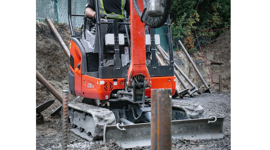 Man in excavator ready to drive helical pile into the ground in Winnipeg