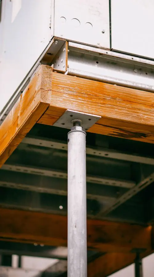 Close up image of a screw pile supporting a metal structure in clay soil