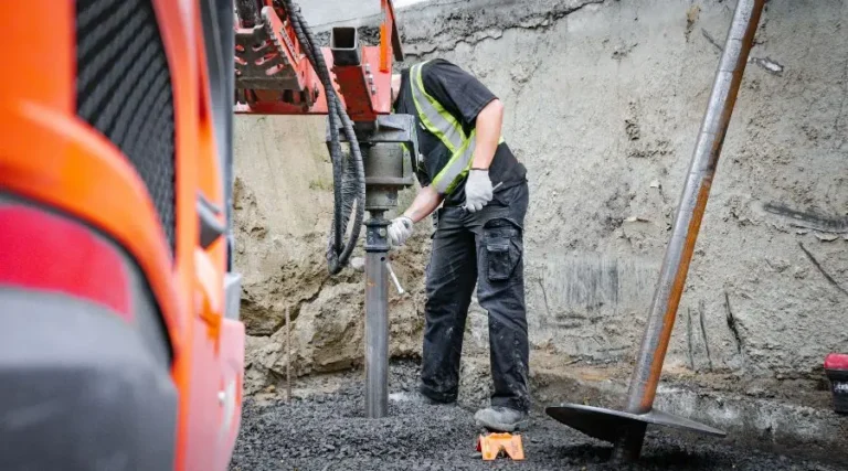 Contractor using equipement to install screw piles in clay