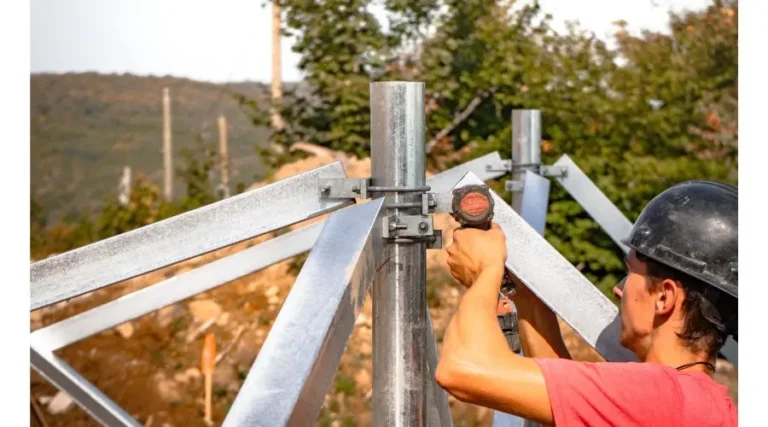 Man installing bracings on screw piles for sloped terrain
